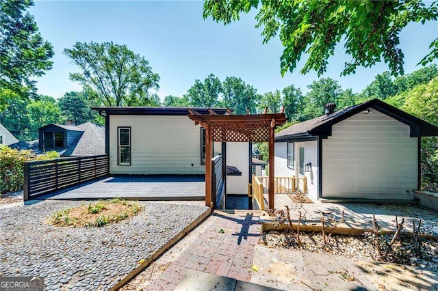 rear view of house with a pergola and a deck