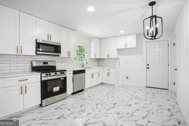 kitchen with a sink, recessed lighting, marble finish floor, light countertops, and appliances with stainless steel finishes
