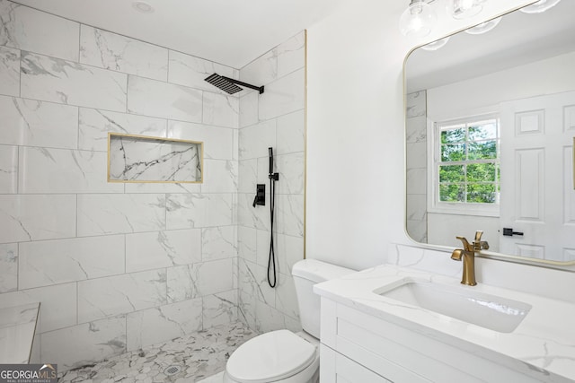 full bathroom featuring toilet, vanity, and tiled shower