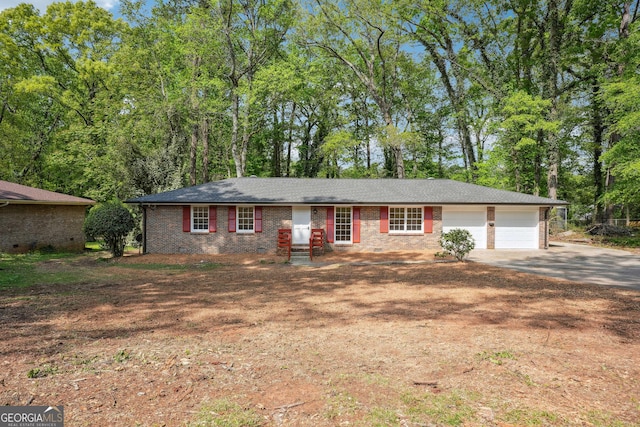 ranch-style home featuring brick siding, an attached garage, and concrete driveway