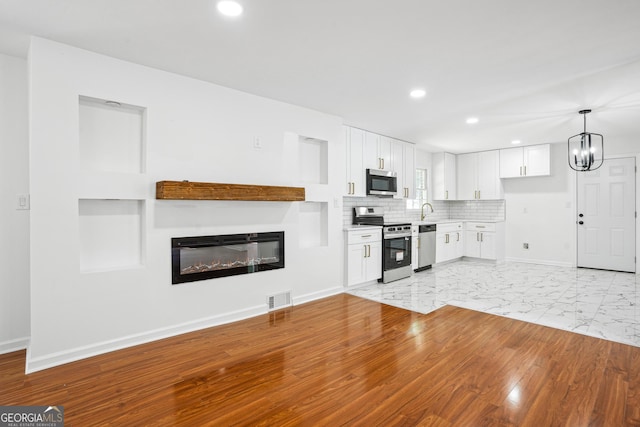 kitchen featuring appliances with stainless steel finishes, baseboards, white cabinetry, visible vents, and recessed lighting