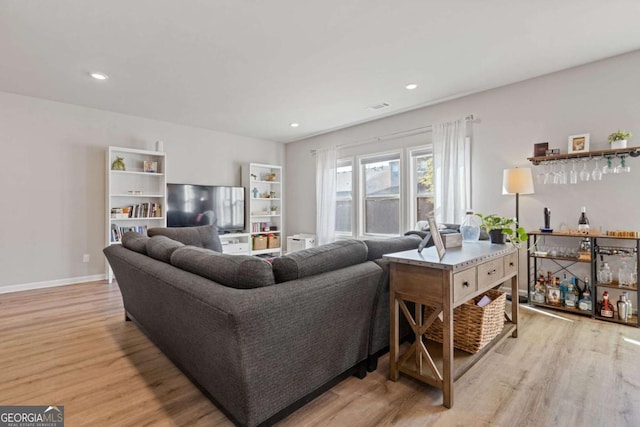 living room with visible vents, light wood finished floors, and recessed lighting