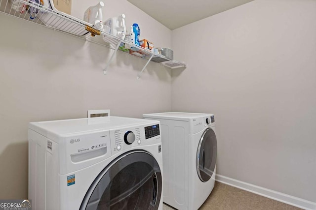 washroom with light colored carpet, washing machine and dryer, baseboards, and laundry area