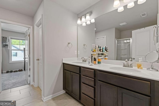 full bath featuring double vanity, a sink, visible vents, and a stall shower