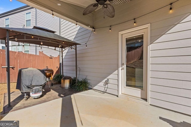 view of patio featuring a gazebo, fence, and ceiling fan