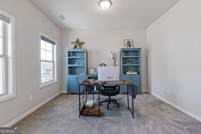 carpeted office space with baseboards and visible vents