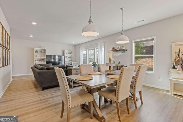 dining area featuring baseboards, light wood finished floors, and plenty of natural light