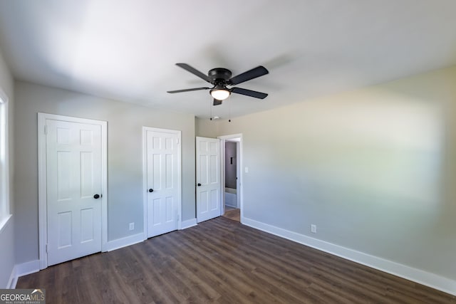 710 Avalon Rd, Thomaston, GA 30286 - unfurnished bedroom with baseboards, multiple closets, dark wood-style flooring, and ceiling fan