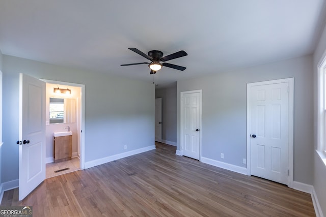 710 Avalon Rd, Thomaston, GA 30286 - unfurnished bedroom with wood finished floors, baseboards, ensuite bath, and a ceiling fan