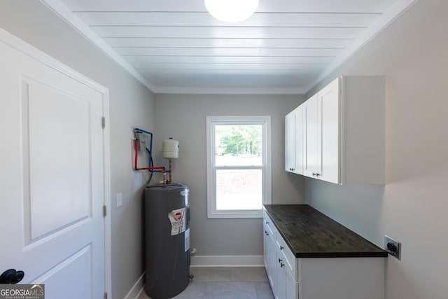 710 Avalon Rd, Thomaston, GA 30286 - washroom featuring water heater, hookup for an electric dryer, baseboards, cabinet space, and light tile patterned floors