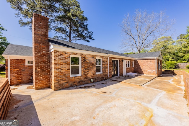 710 Avalon Rd, Thomaston, GA 30286 - back of property with brick siding, a chimney, a patio area, and a shingled roof