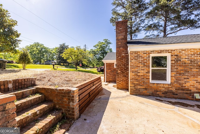 710 Avalon Rd, Thomaston, GA 30286 - view of home's exterior with brick siding, a chimney, and roof with shingles