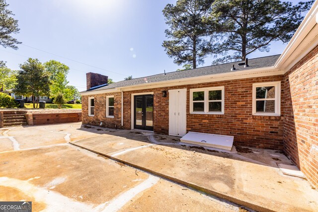 710 Avalon Rd, Thomaston, GA 30286 - back of house with french doors, brick siding, a chimney, and roof with shingles