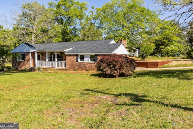 710 Avalon Rd, Thomaston, GA 30286 - view of front facade with covered porch, a front yard, a chimney, and brick siding