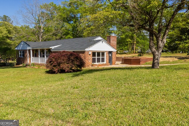 710 Avalon Rd, Thomaston, GA 30286 - view of front of property with a chimney, a front yard, brick siding, and covered porch
