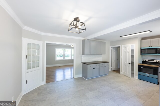 710 Avalon Rd, Thomaston, GA 30286 - kitchen featuring stainless steel appliances, backsplash, crown molding, dark countertops, and baseboards