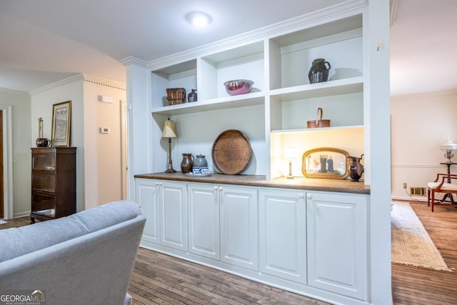 interior space with ornamental molding and wood finished floors