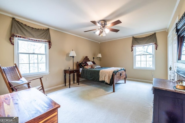 carpeted bedroom with a ceiling fan, baseboards, and crown molding