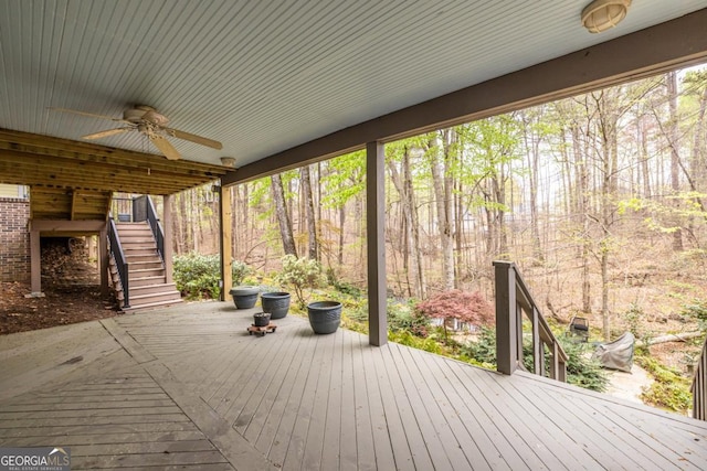 wooden deck featuring ceiling fan and stairway