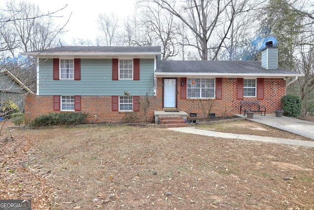 tri-level home with brick siding and a chimney