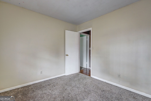 carpeted empty room featuring baseboards