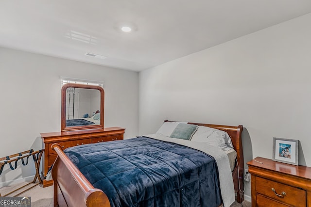 bedroom with baseboards, visible vents, and light colored carpet
