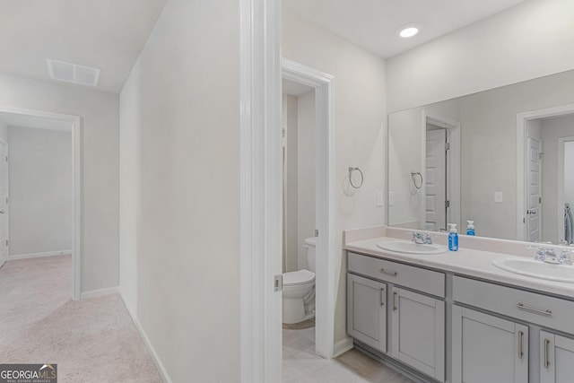 full bath with toilet, visible vents, a sink, and double vanity