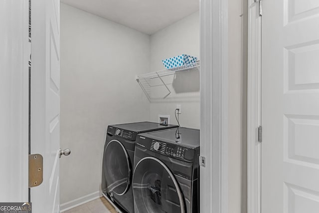 laundry area featuring baseboards, separate washer and dryer, and laundry area