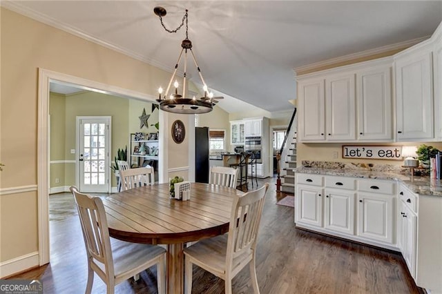 dining area featuring an inviting chandelier, dark wood-style flooring, and stairs