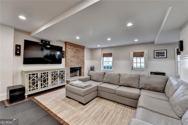 living room with recessed lighting, a decorative wall, a wainscoted wall, and a fireplace