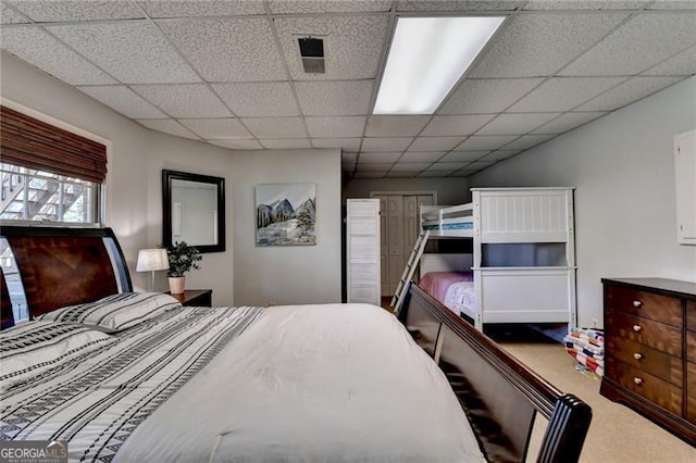 bedroom featuring carpet floors, visible vents, and a paneled ceiling