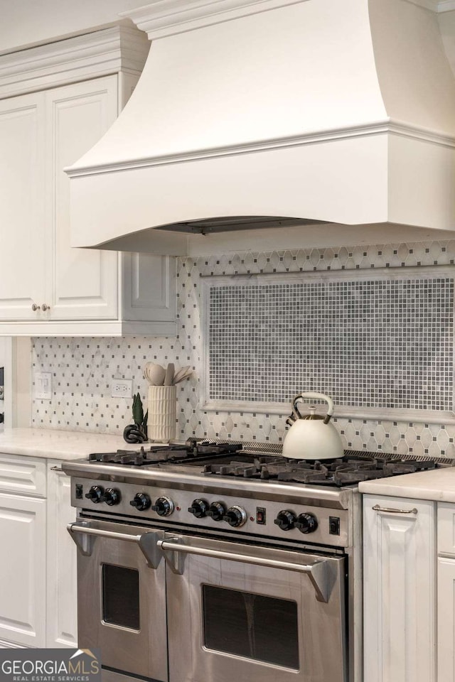 3511 Roxboro Rd NE, Atlanta, GA 30326 - kitchen with white cabinets, light countertops, tasteful backsplash, and double oven range