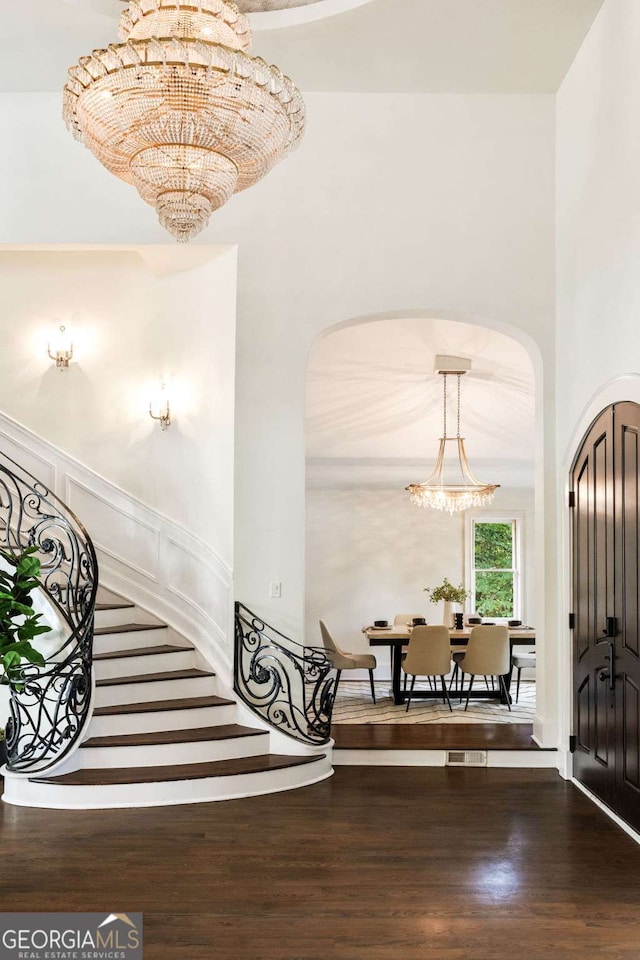 3511 Roxboro Rd NE, Atlanta, GA 30326 - foyer entrance with a towering ceiling, an inviting chandelier, wood finished floors, arched walkways, and stairs