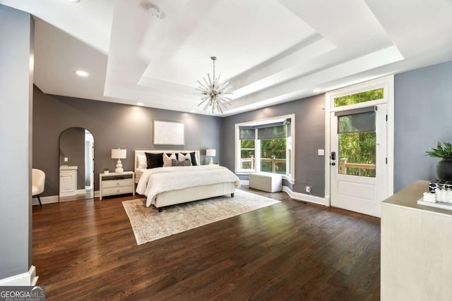 3511 Roxboro Rd NE, Atlanta, GA 30326 - bedroom featuring arched walkways, dark wood finished floors, an inviting chandelier, and a tray ceiling
