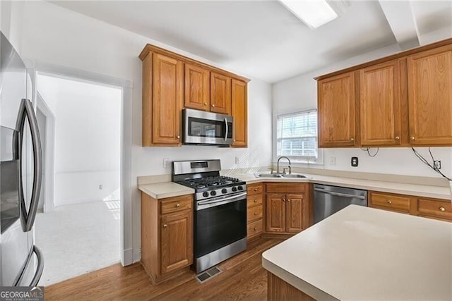 1268 Windsor Glen Dr, Douglasville, GA 30134 - kitchen with stainless steel appliances, a sink, dark wood-style flooring, visible vents, and brown cabinetry