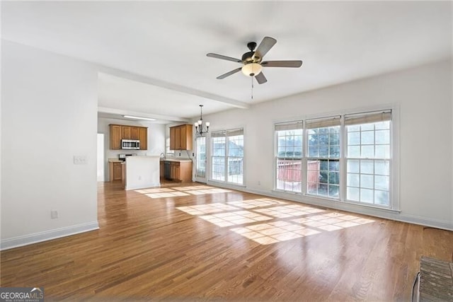 1268 Windsor Glen Dr, Douglasville, GA 30134 - unfurnished living room with baseboards, wood finished floors, and ceiling fan with notable chandelier