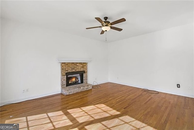 1268 Windsor Glen Dr, Douglasville, GA 30134 - unfurnished living room with baseboards, a ceiling fan, wood finished floors, and a fireplace