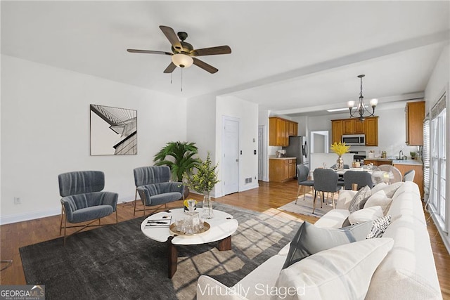 1268 Windsor Glen Dr, Douglasville, GA 30134 - living area featuring wood finished floors, visible vents, baseboards, and ceiling fan with notable chandelier