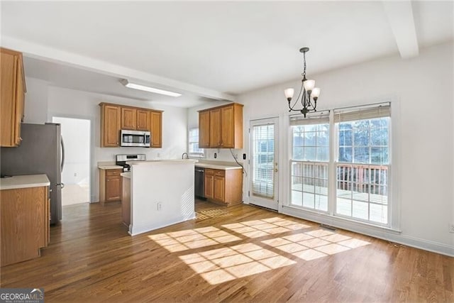 1268 Windsor Glen Dr, Douglasville, GA 30134 - kitchen with brown cabinets, wood finished floors, a notable chandelier, and appliances with stainless steel finishes