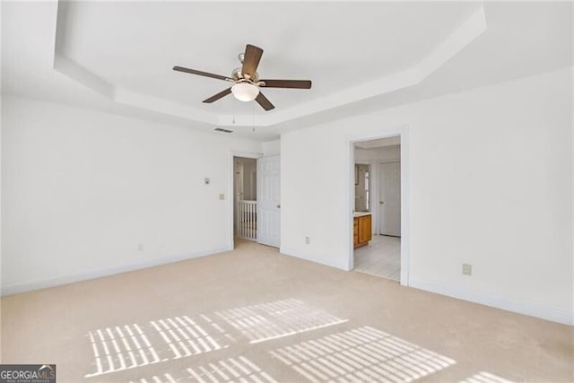 1268 Windsor Glen Dr, Douglasville, GA 30134 - unfurnished bedroom with ensuite bathroom, a raised ceiling, light colored carpet, baseboards, and visible vents