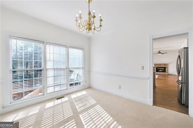 1268 Windsor Glen Dr, Douglasville, GA 30134 - unfurnished room featuring visible vents, baseboards, a notable chandelier, carpet floors, and a lit fireplace