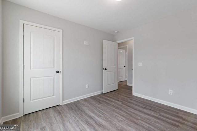 unfurnished bedroom with baseboards and wood finished floors