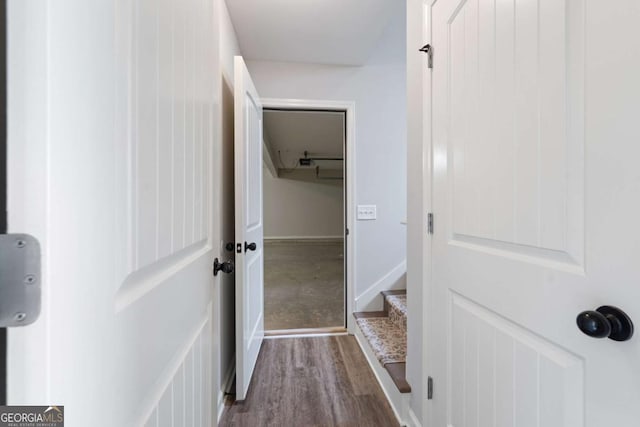 corridor with dark wood finished floors and baseboards