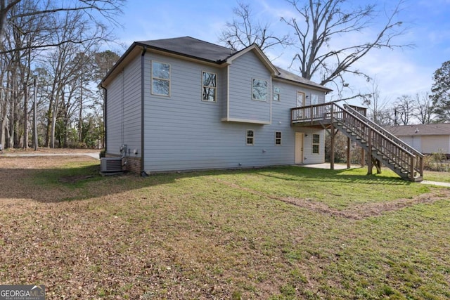 rear view of house with central AC, a wooden deck, a patio area, a lawn, and stairway