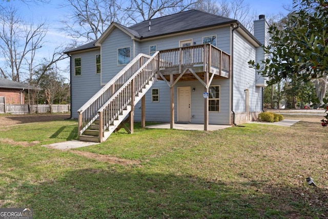 rear view of house featuring a chimney, stairs, a yard, a patio, and a deck