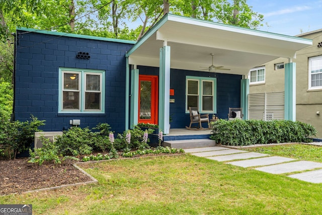 830 Belgrade Ave NE, Atlanta, GA 30306 - view of front of house with ceiling fan, covered porch, a front yard, and concrete block siding