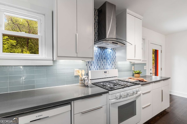 830 Belgrade Ave NE, Atlanta, GA 30306 - kitchen with dark wood-style flooring, white appliances, white cabinetry, and wall chimney range hood