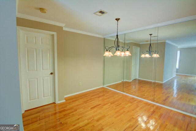 1005 Berkeley Woods Dr, Duluth, GA 30096 - spare room featuring wood finished floors, a chandelier, baseboards, crown molding, and a smoke detector