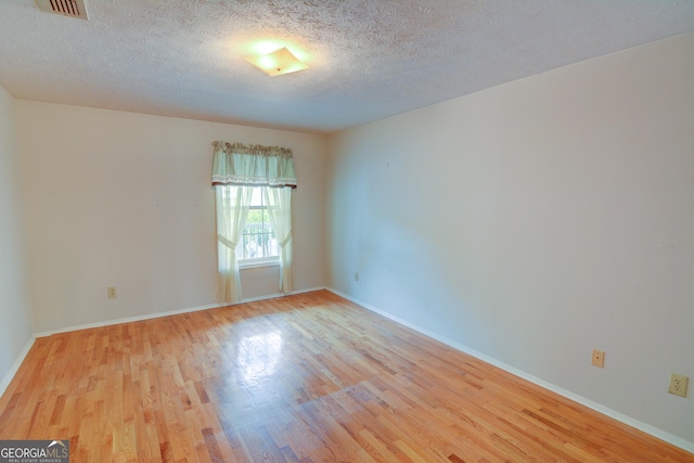 1005 Berkeley Woods Dr, Duluth, GA 30096 - unfurnished room with wood finished floors, a textured ceiling, and baseboards