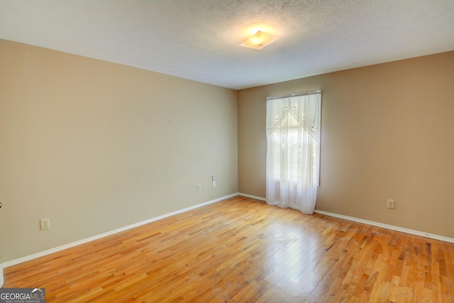 1005 Berkeley Woods Dr, Duluth, GA 30096 - empty room featuring light wood-style flooring, baseboards, and a textured ceiling